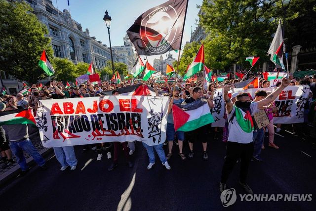 14일(현지시간) 사이클 대회 '부엘타 아 에스파냐'의 스페인 마드리드 도심 코스를 점거한 팔레스타인 지지 시위대.[AFP=연합뉴스. 재판매 및 DB 금지]