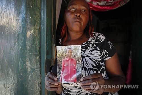 2012년 살해당한 동생 아그네스 완지루의 사진을 들고 있는 언니