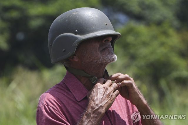 지난 13일(현지시간) 헬멧 착용하는 베네수엘라 민병대원