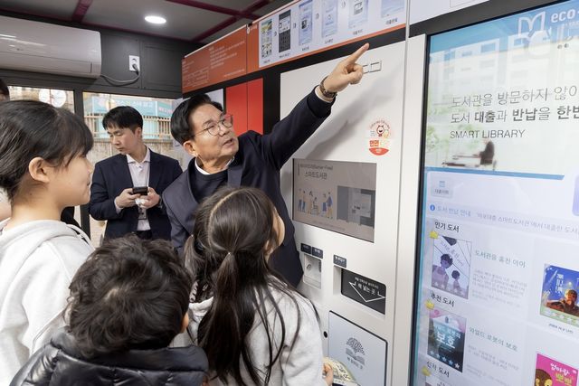 아이들에게 도서관 이용방법을 알려주는 박강수 구청장