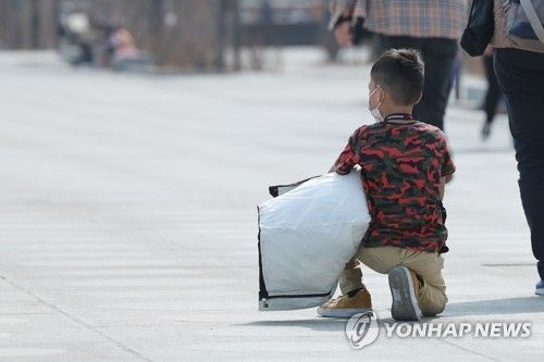 햇볕 아래 앉아 있는 아이