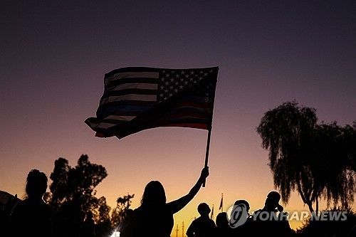 찰리 커크 추모 집회에서 성조기 흔드는 미국인