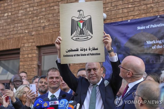 주영 팔레스타인 대표가 '팔레스타인 국가 대사관' 명판을 들어 보이고 있다