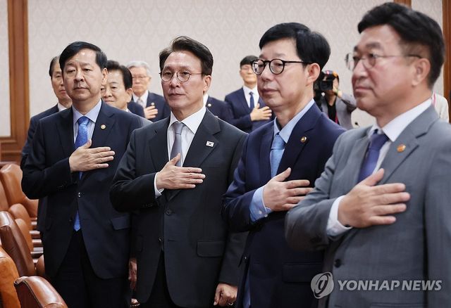 국기에 경례하는 김민석 총리