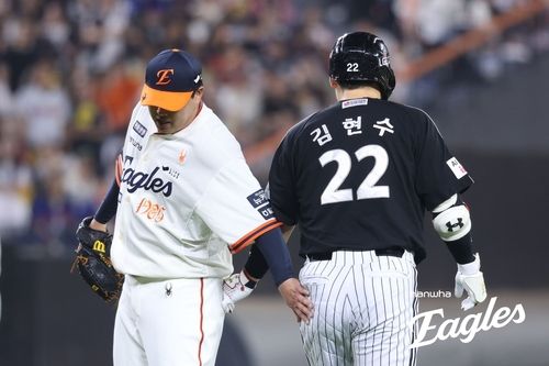 김현수의 엉덩이를 툭 치는 류현진