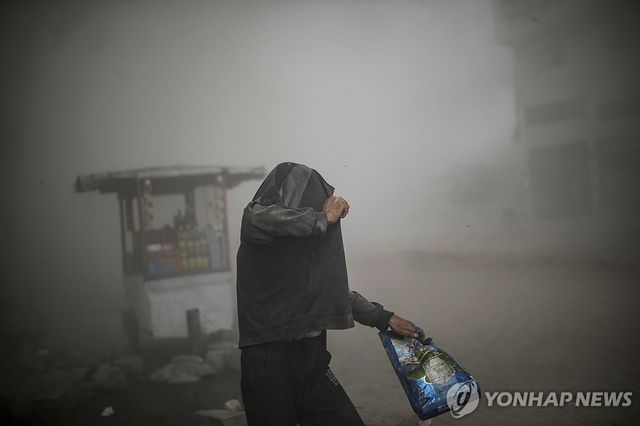 27일(현지시간) 가자시티에서 이스라엘군의 공습 직후 옷으로 몸을 가리는 팔레스타인 주민 
