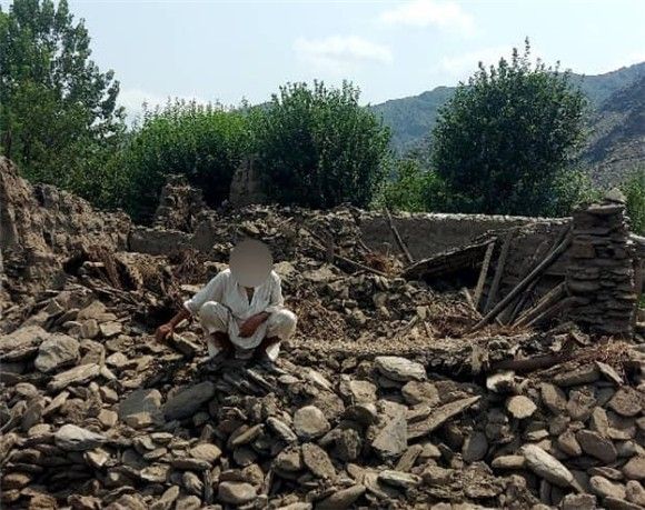 아프가니스탄 쿠나르 주에 지진으로 무너진 주택 잔해 위에 있는 주민