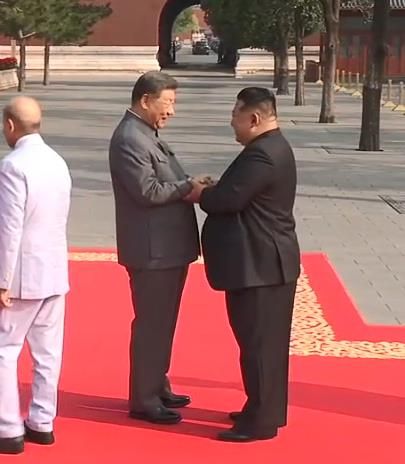 시진핑 중국 국가주석(왼쪽)과 김정은 북한 국무위원장이 두 손을 맞잡고 인사하는 장면