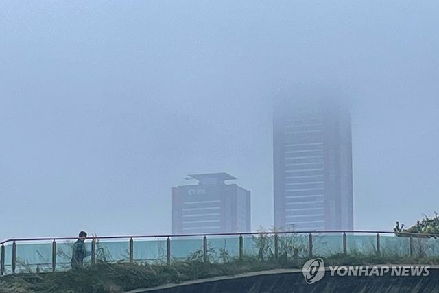 안개가 짙게 낀 서울 영등포구 여의도 한강 둔치의 구름다리를 건너고 있다. [연합뉴스 자료사진]