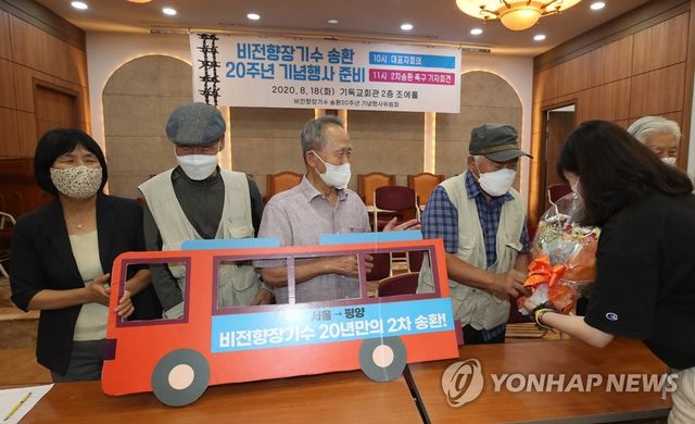 2020년 8월 18일 오전 서울 종로구 기독교회관에서 열린 '비전향장기수 송환 20주년 기념행사 준비 및 2차 송환 촉구'기자회견에서 송환버스 판넬을 든 비전향장기수들이 꽃다발을 전달받고 있다. 왼쪽 두번째부터 박희성 양희철 김영식. [연합뉴스 자료사진]