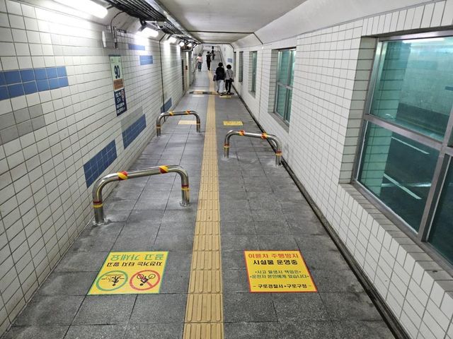 신도림지하보도 입구에 설치된 진입 방지용 U자형 길말뚝과 바닥 안내 문구