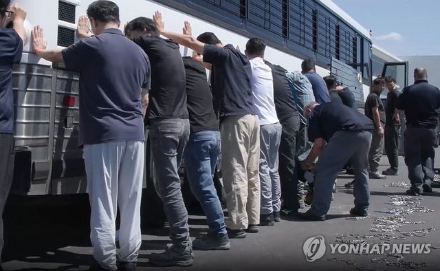 양손과 다리에 체인 묶는 단속요원들