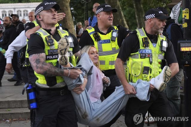 6일 영국 경찰이 런던 '팔레스타인 행동' 지지 시위자를 붙잡고 있다.