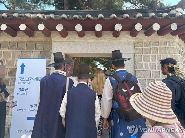 나란히 갓 쓰고 경복궁 향하는 외국인 관광객들