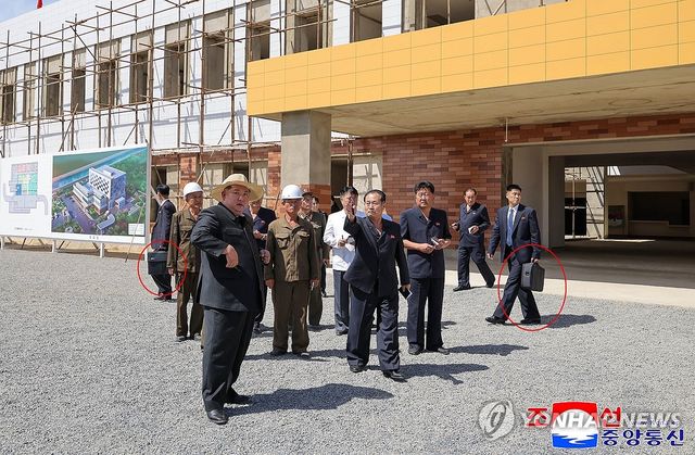 가방 들고 김정은 경호하는 북한 경호원들