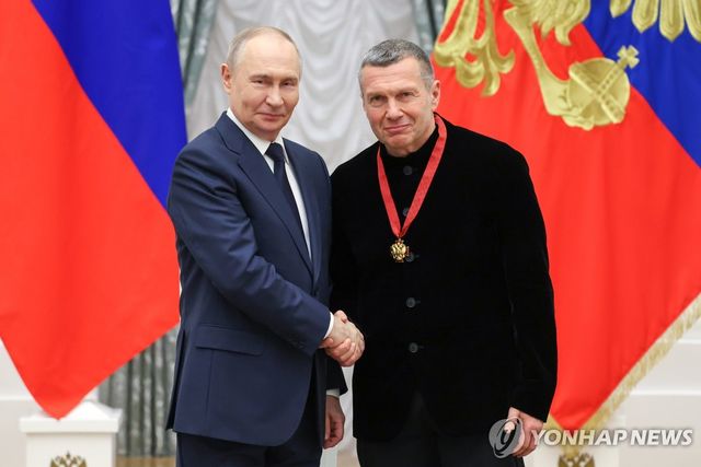 블라디미르 푸틴 러시아 대통령과 악수하는 솔로비요프(오른쪽)