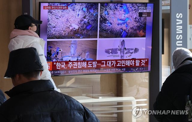 서울역에서 무인기 관련 뉴스 보는 시민들