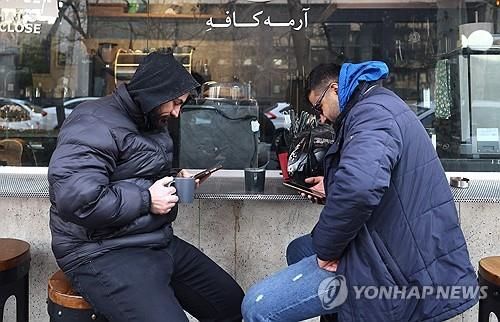 이달 초 테헤란에서 핸드폰 보는 시민들