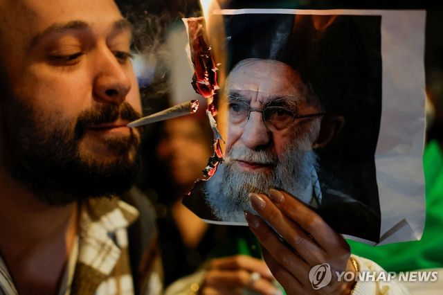 이란 최고 지도자 그림 태워 담뱃불 붙이는 남성