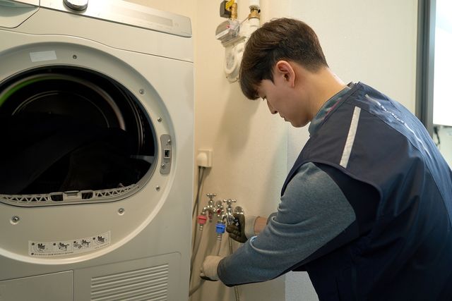 세탁기 수도 연결부를 확인하는 삼성전자서비스 엔지니어