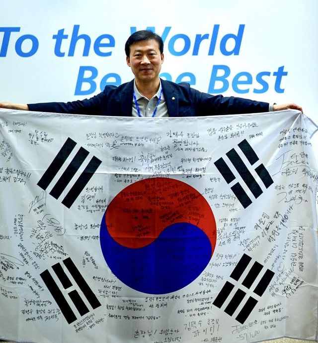 선수·지도자 사인이 담긴 태극기를 들어 보인 김택수 촌장