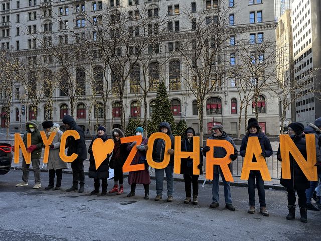 맘다니 취임 축하행사장 앞 대형문구를 든 지지자들