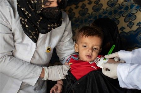 IRC 의료진이 아프간에서 10개월 된 영양실조 어린이를 진료하고 있다.