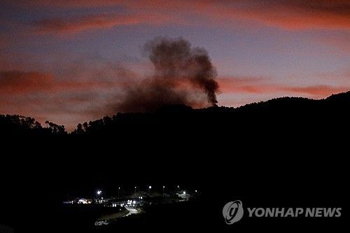 마두로 체포작전 당시 불꺼진 수도 카라카스에 연기가 피어오르는 모습