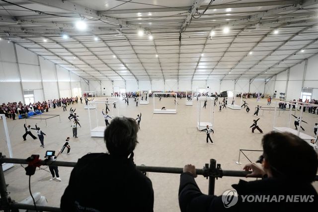 이탈리아 밀라노에 설치된 대형 텐트에서 올림픽 개회식 리허설을 펼치는 자원봉사자들