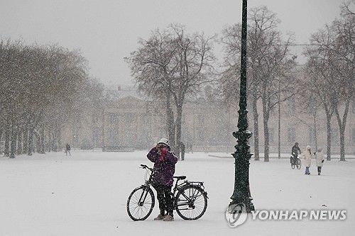 눈 내린 5일(현지시간) 파리 샹드마르스의 시민