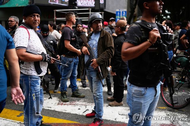 4일 베네수엘라 수도 카라카스에서 열린 니콜라스 마두로 대통령 석방 요구 시위에서 친(親)마두로 민병대원이 총을 들고 서 있다. [AP=연합뉴스]