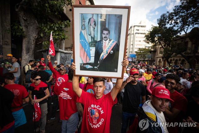 4일 베네수엘라 수도 카라카스에서 열린 니콜라스 마두로 대통령 석방 촉구 시위에서 한 남성이 마두로 대통령 사진을 들고 있다.[EPA=연합뉴스]