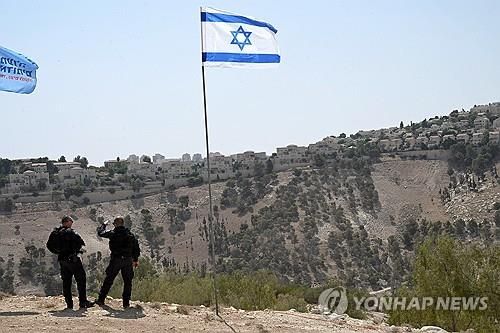 이스라엘 요원들이 EI지역과 붙어있는 마알레 아두밈 정착촌을 배경으로 서있는 모습 [UPI=연합뉴스 자료사진. 재판매 및 DB금지]