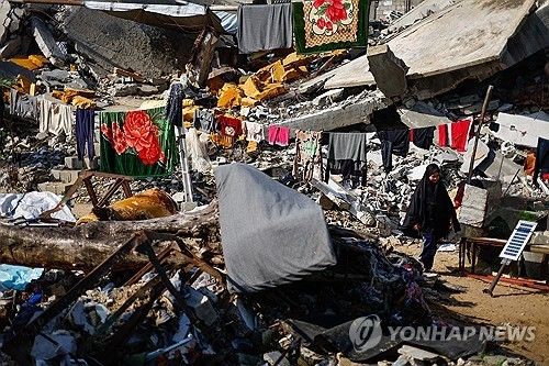 파괴된 건물 잔해 사이 걸어가는 팔레스타인 소녀