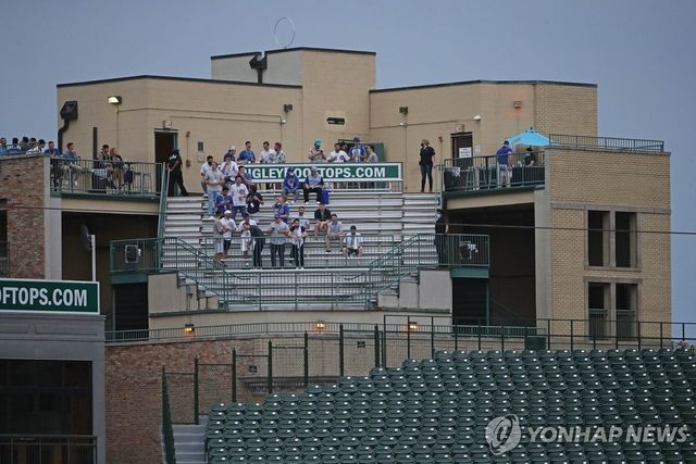 리글리필드 외부 건물 옥상 '특설 관중석'에서 경기보는 야구팬들