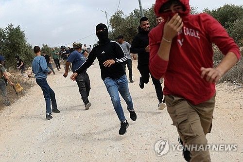 요르단강 서안 아부 팔라 마을에서 이스라엘 정착민들이 올리브를 수확 중이던 팔레스타인 가족을 공격한 직후, 주민들이 이스라엘군의 최루탄을 피해 황급히 몸을 숨기고 있다.[EPA 연합뉴스. 재판매 및 DB 금지]