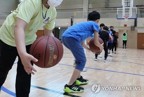 초등학교 체육관에서 운동하는 학생들