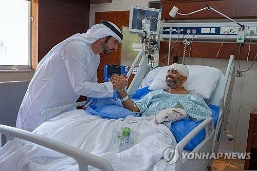 아랍에미리트(UAE) 아부다비의 한 병원에서 셰이크 함단 빈 무함마드 빈 라시드 알막툼 두바이 왕세자(왼쪽)가 부상을 입은 인도 국적의 플라이두바이 소속 스미트 마차르 기장을 위문하고 있다.[AP 연합뉴스. 재판매 및 DB 금지]