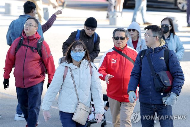 두꺼운 옷 입은 외국인 관광객들