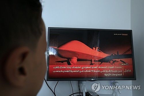 22일(현지시간) 예멘 수도 사나에서 한 남성이 사우디아라비아와 후티 반군 간의 무력 충돌 관련 보도를 지켜보고 있다.[로이터 연합뉴스. 재판매 및 DB 금지]