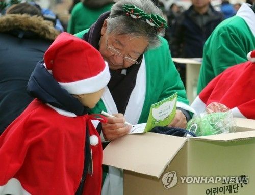 산타 복장을 하고 어린이를 만난 최불암 후원회장