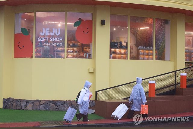 비옷 입고 여행하는 관광객들