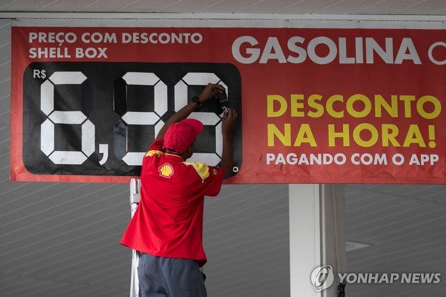 19일 브라질 리우데자네이루의 한 주유소에서 휘발유 가격을 바꾸는 직원 