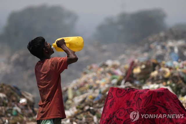 인도 잠무 외곽 쓰레기 하치장에서 한 남성이 물을 마치고 있다. [AP=연합뉴스 자료사진. 재판매 및 DB 금지]