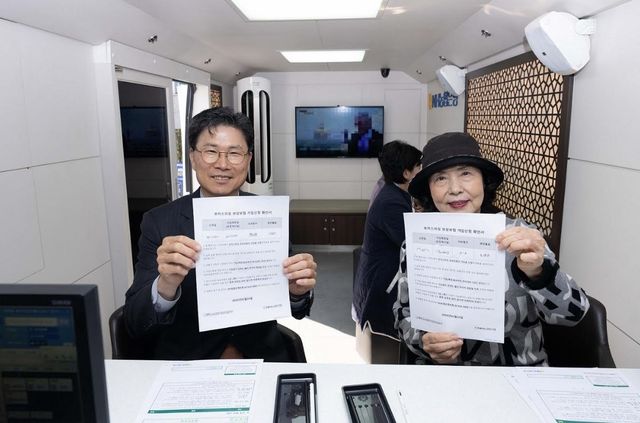 강태영 NH농협은행 행장(왼쪽)이 24일 오전 경기 남양주시 다산노인복지관에서 보이스피싱 보상 보험을 가입한 고객과 기념촬영을 하고 있다. [농협은행 제공]