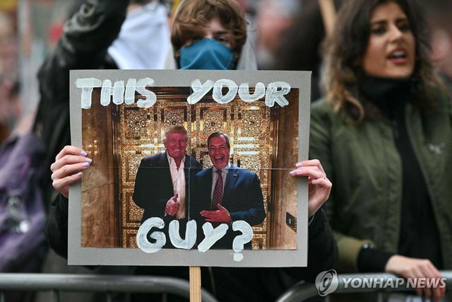 선거 유세장 앞의 영국개혁당 반대 시위대가 트럼프 대통령과 패라지 대표가 함께 찍은 사진을 들고 있다