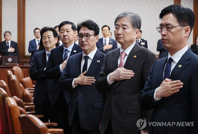 국기에 경례하는 김민석 총리와 국무위원들