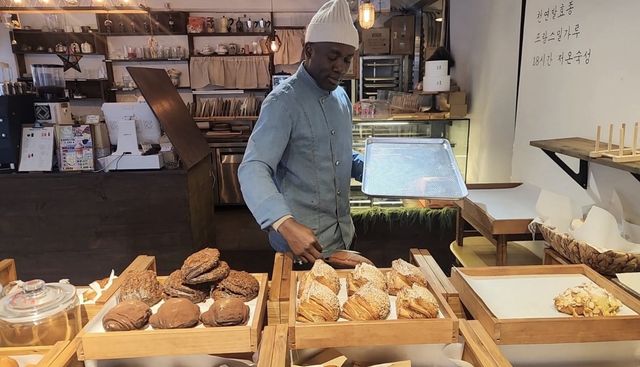 매대에 빵을 진열하고 있다.