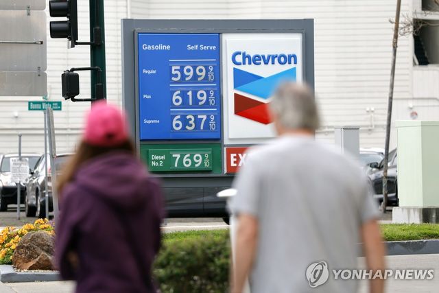 휘발유 가격 고지판을 보는 미국 시민들 