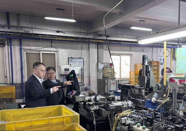 정진완 우리은행장(왼쪽)이 국내 중소기업을 방문해 생산 현장에 대해 관계자로부터 설명을 듣고 있다. [우리은행 제공]